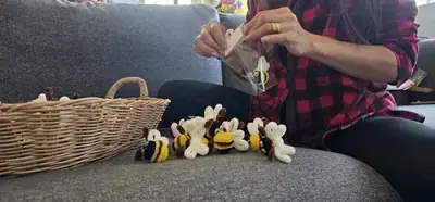 Artisan hands attaching Handmade tag to packaged bee gift